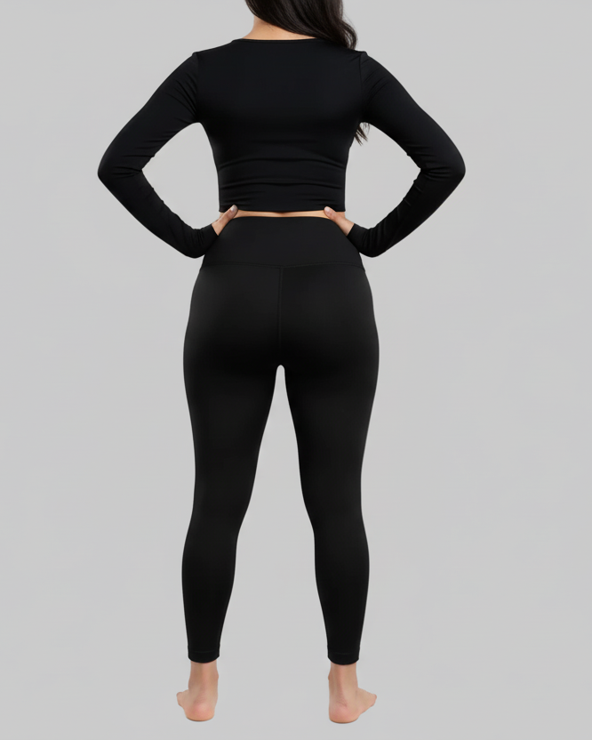 Person wearing a black athletic outfit on a gray background