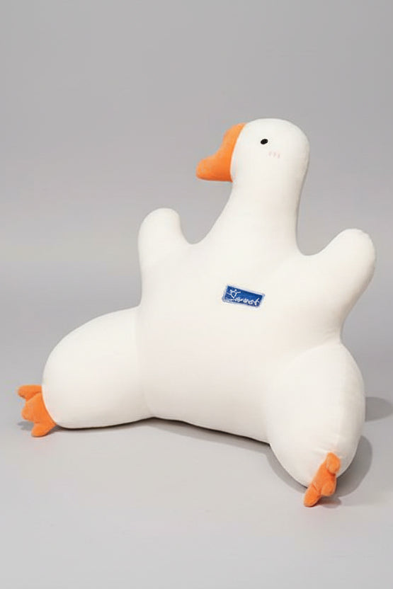 White goose-shaped pillow with orange feet and beak on a chair in an office setting.