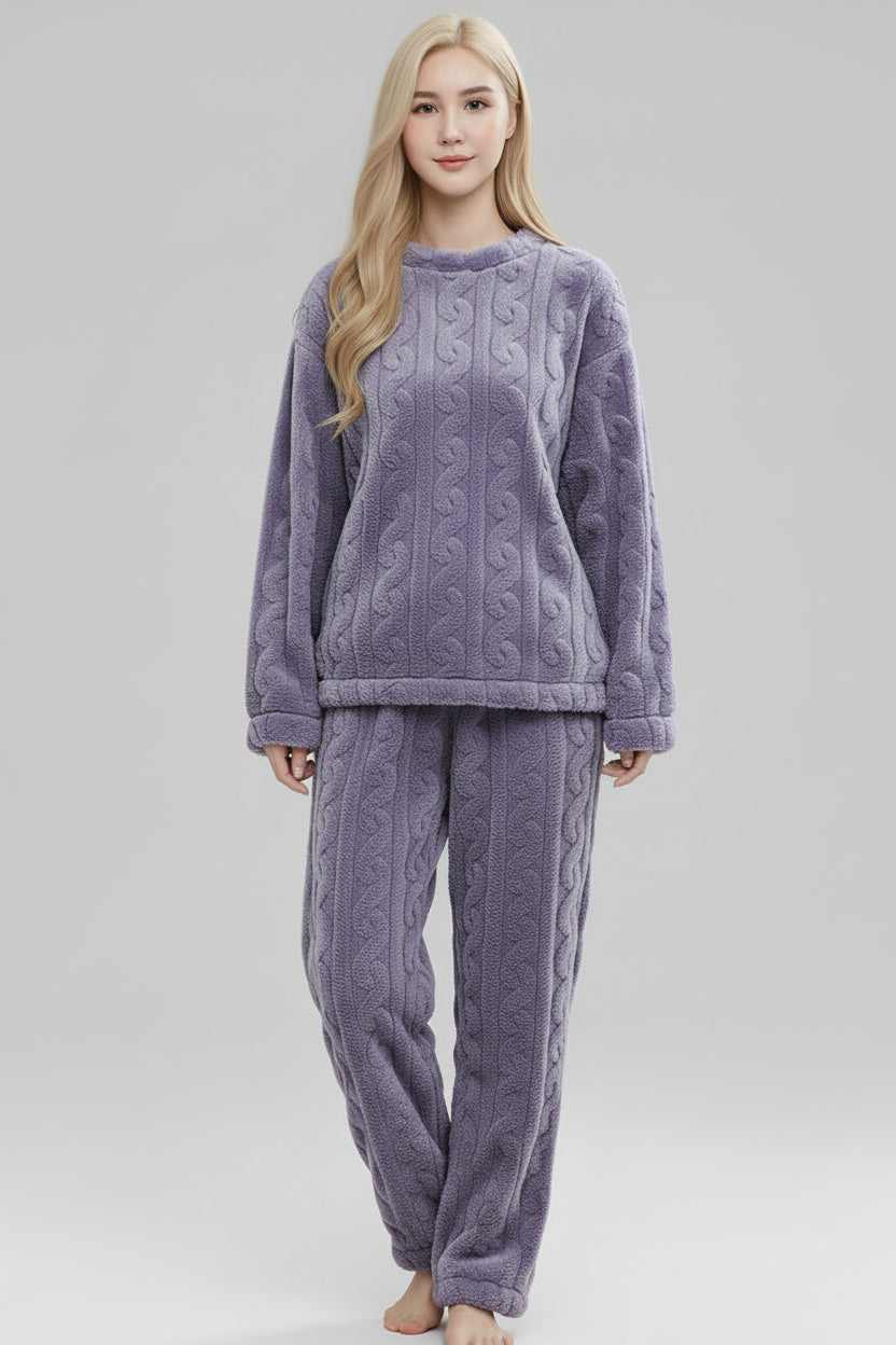Woman wearing a purple cable knit pajama set on a gray background