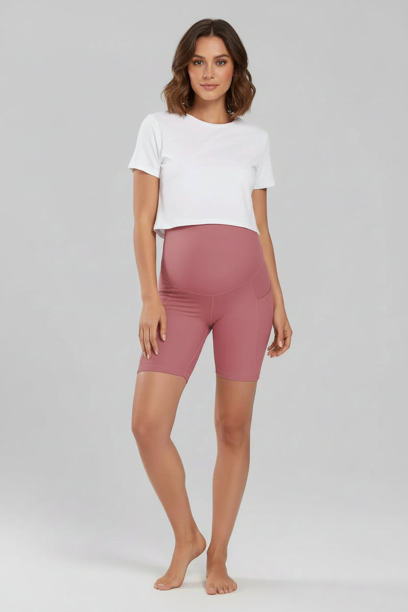 Person wearing pink high-waisted bike shorts on a gray background