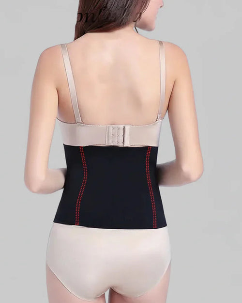 Woman wearing a black compression garment with red accents on a gray background