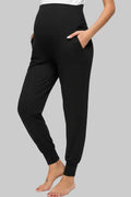 Black jogger pants worn by a person on a gray background