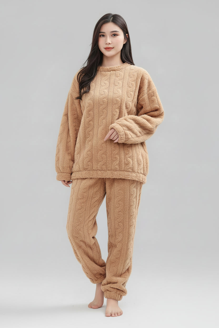 Woman wearing a beige cable-knit loungewear set on a plain background
