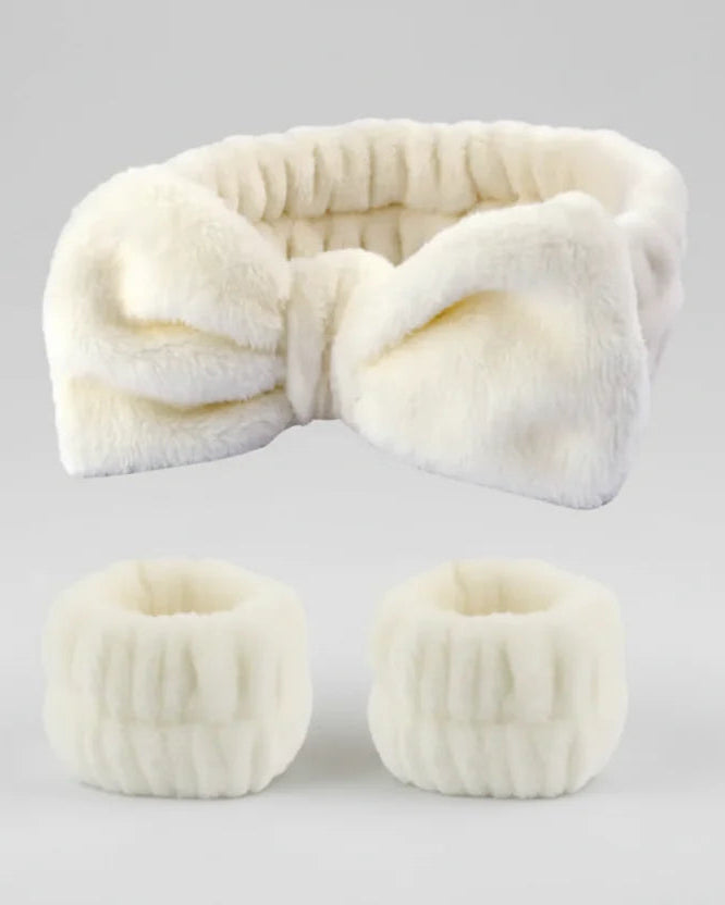 White fur headband and matching eye masks on a light gray background
