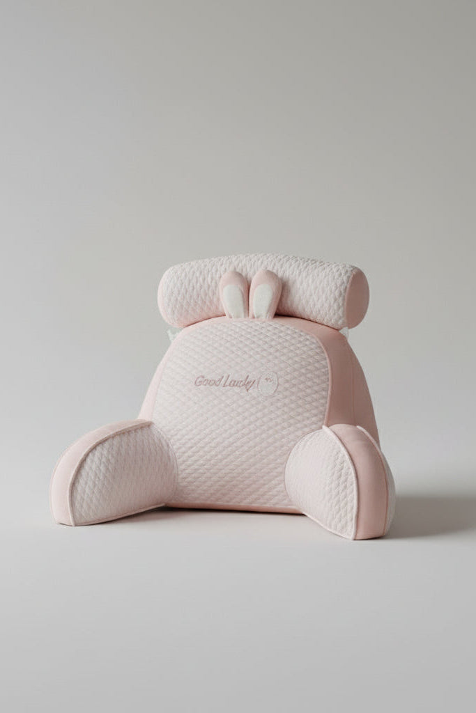 Pink plush toy with 'Good Lucky' text on a surface with a magazine in the background.