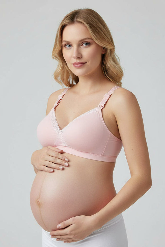 Pink bra on a white surface with a black handbag and makeup items.