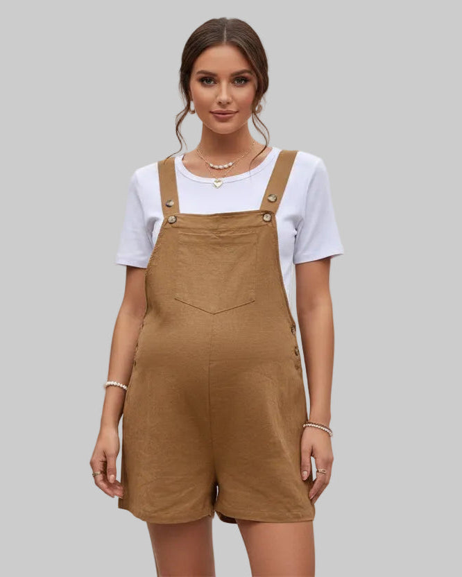 Woman wearing a white t-shirt and brown overalls on a gray background