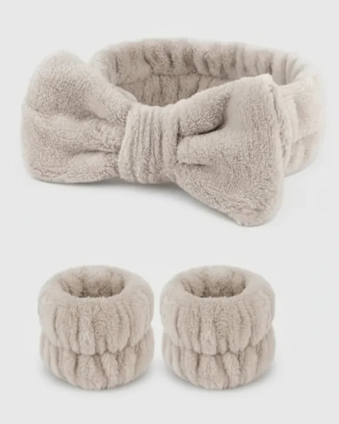 Set of beige knitted headband and hair ties on a white background
