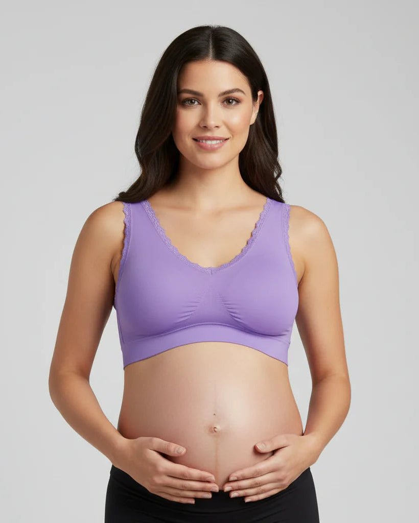 Pregnant woman wearing a purple maternity bra against a gray background