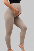 Beige leggings worn by a person on a gray background