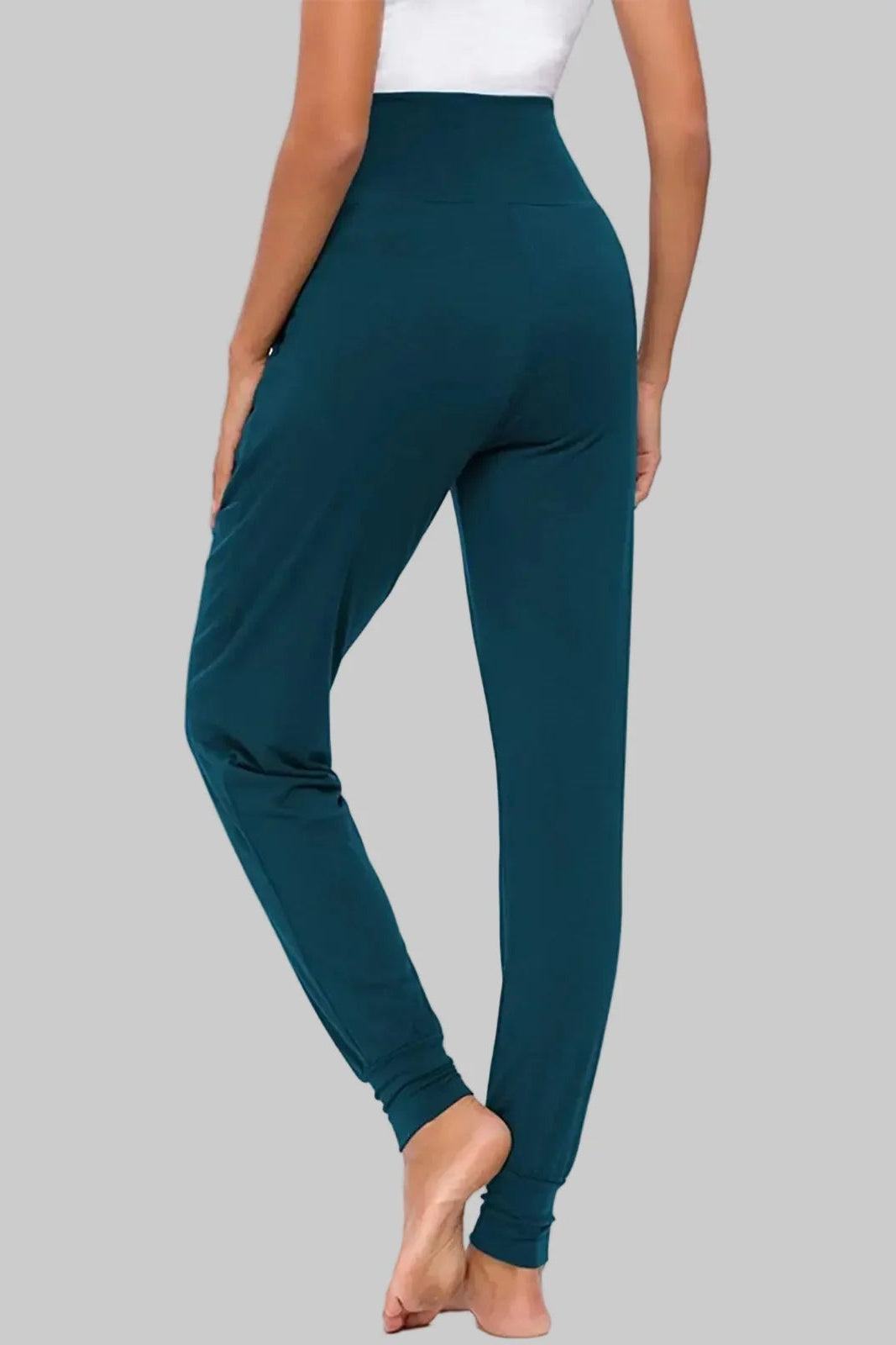 Teal leggings worn by a person on a gray background