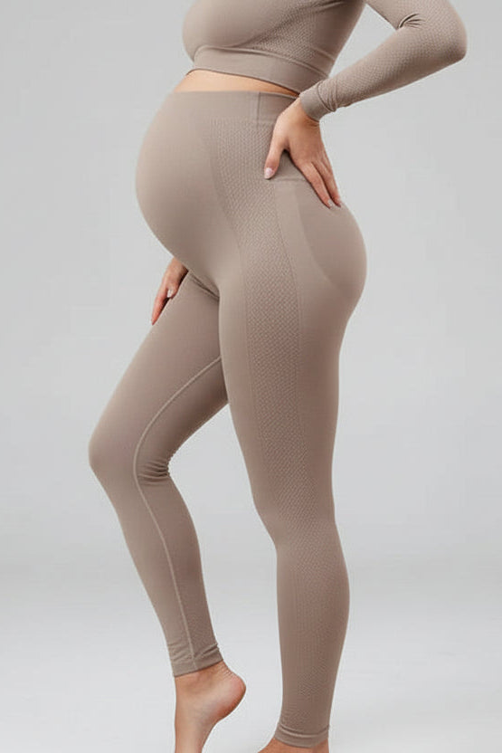 Person wearing beige leggings and top on a light gray background