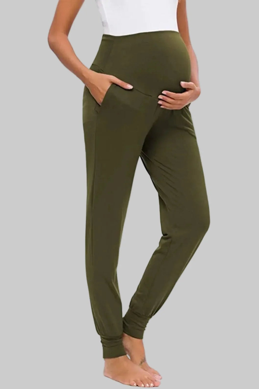 Person wearing olive green pants on a gray background