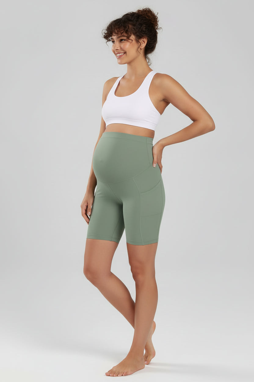 Person wearing green athletic shorts on a plain background